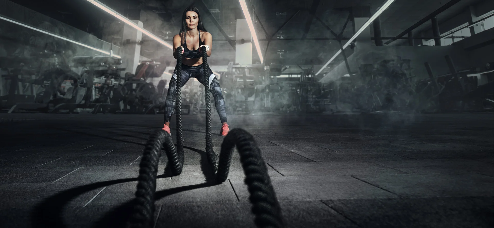 A rejuvenated woman training with battle ropes
